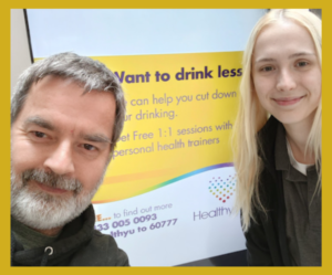 KC from The SUN Network and Philippa from HealthyYou smiling for a photo
in front of a drink less poster