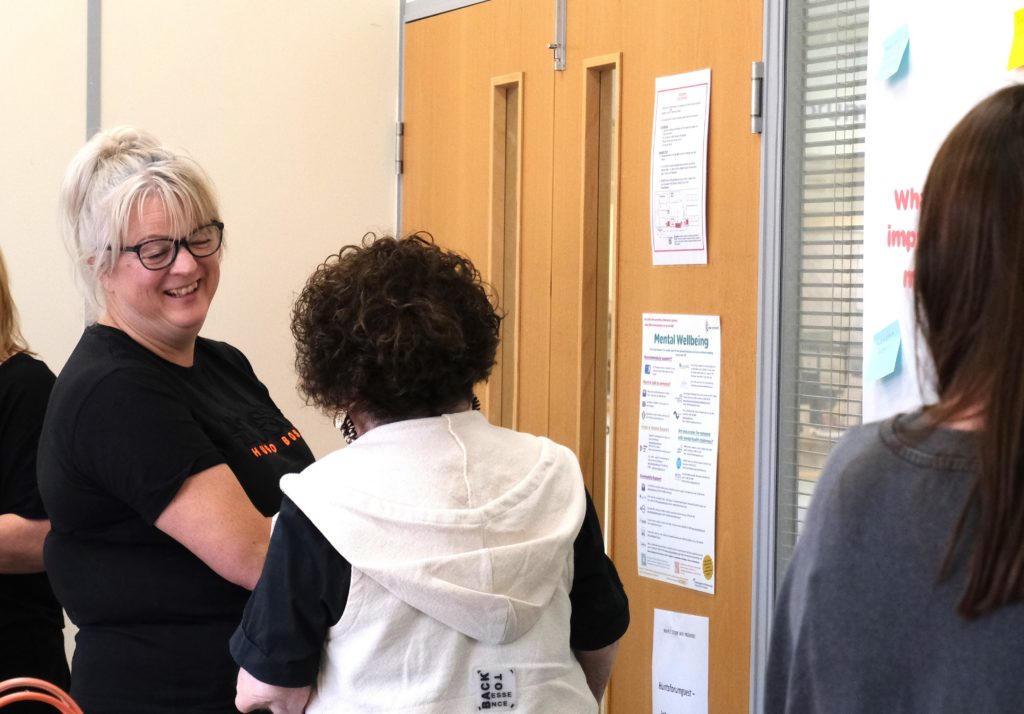 A group of people smiling and chatting about menopause